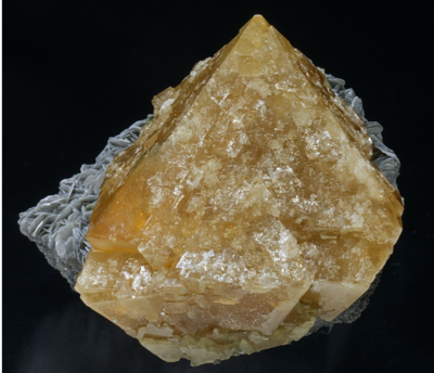 Cristal de Scheelita com cor amarelada implantada em uma matriz de cristais de Muscovita. Fabreminerals.com